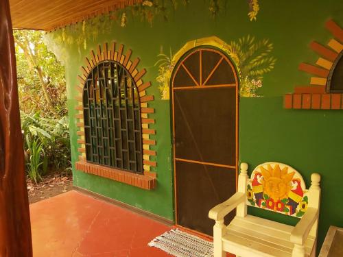 a play house with a door and a bench at La Palapa Hut Nature Hostel in Puerto Jiménez
