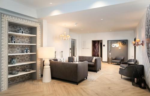 a living room with a couch and chairs at elaya hotel regensburg city center in Regensburg