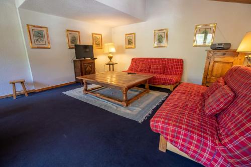 un salon avec deux canapés rouges et une table dans l'établissement Sherpa 18 on the Mottaret snowfront, à Méribel