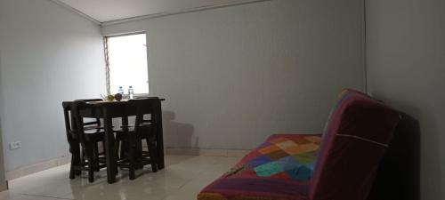 a living room with a chair and a table at Apartamento con linda terraza en San Antonio in Cali