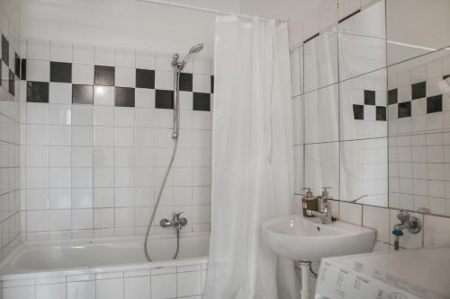 ein Bad mit einer Badewanne, einem Waschbecken und einer Dusche in der Unterkunft Spacious 2BR Apt. Rennweg - Perfect for Longstays. in Wien