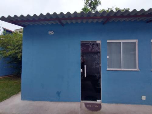 um edifício azul com uma janela e uma porta em Suites para casais na praça Oswaldo Cruz em Cabo Frio
