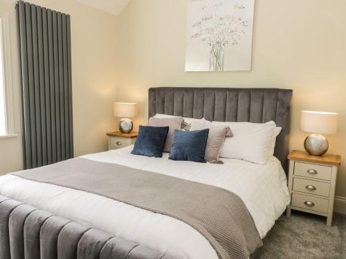 een slaapkamer met een groot bed met blauwe kussens bij Partridge Place in Hull