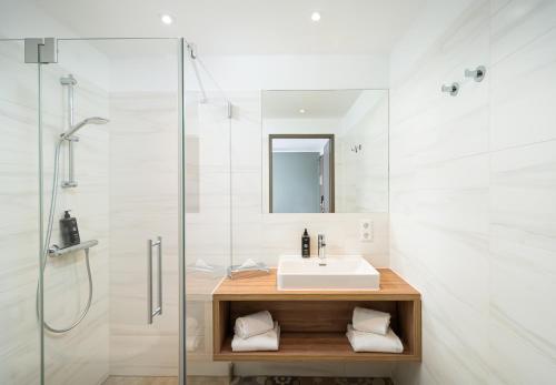 a bathroom with a sink and a shower at elaya hotel regensburg city center in Regensburg