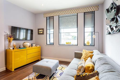 a living room with a couch and a yellow dresser at Exmouth Market Apartment in London