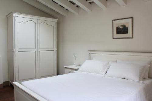 ein weißes Schlafzimmer mit einem weißen Bett und weißen Kissen in der Unterkunft Villa Trieste M in Asolo