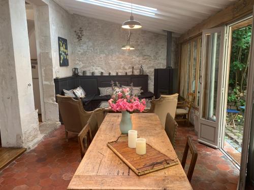 una mesa de madera con un jarrón de flores. en La petite maison en Crépy-en-Valois