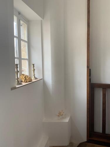 a bathroom with a window and a white wall at La petite maison in Crépy-en-Valois