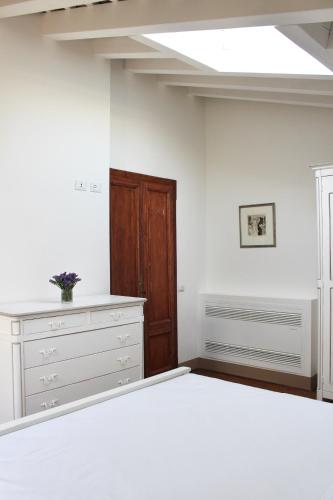 ein weißes Schlafzimmer mit einem Bett und einem Dachfenster in der Unterkunft Villa Trieste M in Asolo