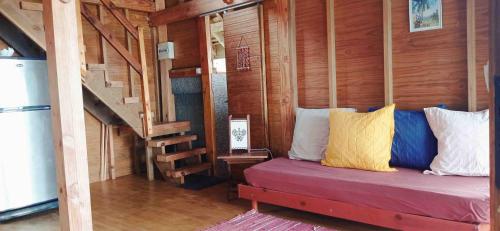 una camera con un letto in una cabina di legno di RAIATEA - The BEACH HOUSE - plage sur le lagon ! a Tevaitoa