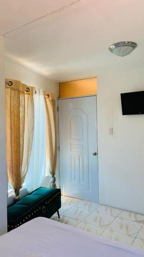 a bedroom with a bed and a door with curtains at Villa Marcia in Boca Chica