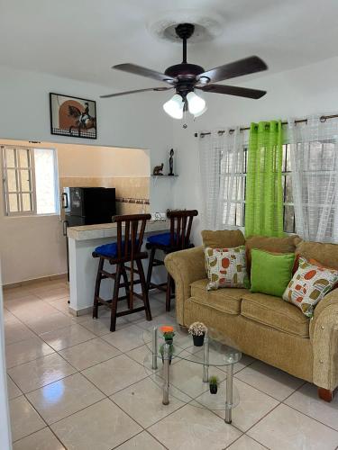 a living room with a couch and a ceiling fan at Villa Marcia in Boca Chica