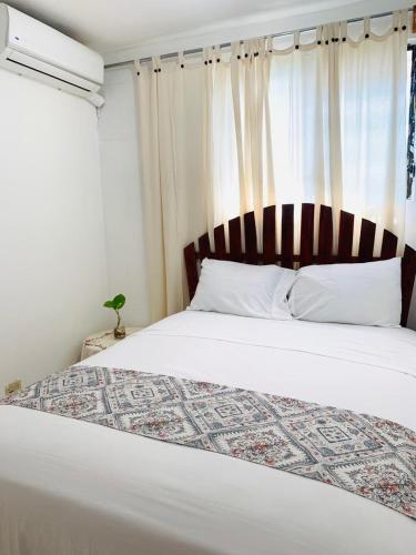 a bedroom with a large bed and a window at Villa Marcia in Boca Chica