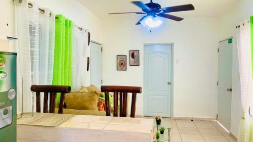 a dining room with a ceiling fan and a table at Villa Marcia in Boca Chica