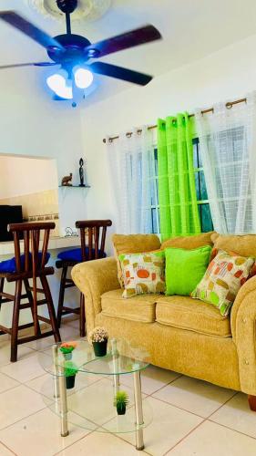 a living room with a couch and a ceiling fan at Villa Marcia in Boca Chica