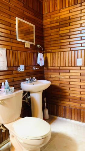 a bathroom with a toilet and a sink at Villa Marcia in Boca Chica