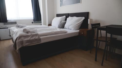 a bedroom with a bed with white sheets and pillows at Hotel U Ševce in Zlín