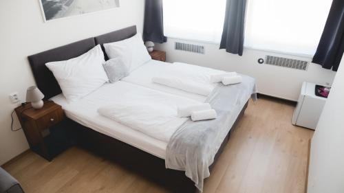 a bedroom with a large bed with white sheets and pillows at Hotel U Ševce in Zlín