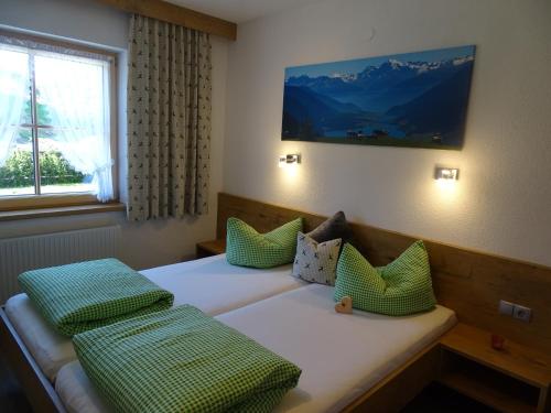 1 dormitorio con 2 camas y almohadas verdes en Mutzkopf en Nauders