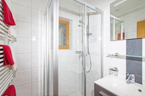 baño blanco con ducha y lavamanos en Mutzkopf en Nauders