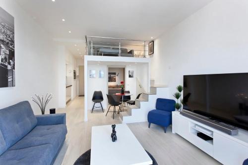 un salon avec un canapé bleu et une télévision dans l'établissement REF 1196 - Cannes Croisette - Sea view apartment for rent, à Cannes