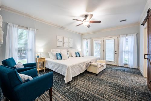 a bedroom with a bed and two blue chairs at Relax In Private Pool & Cozy Gazebo At Param Farms in Cartersville