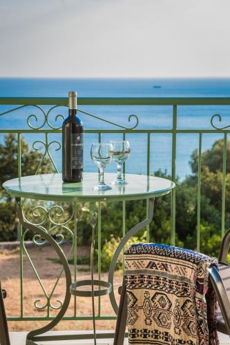 a glass table with two wine glasses on a balcony at Eagle's Nest in Lourdhata