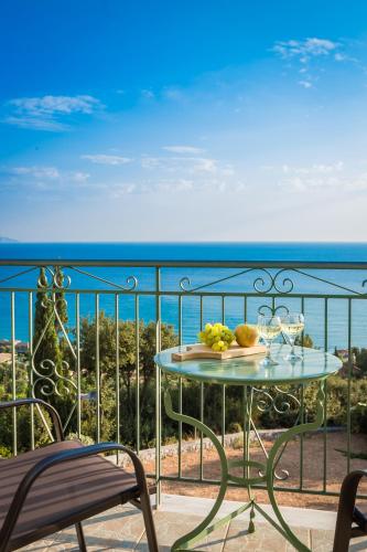 a table and chairs on a balcony with the ocean at Eagle's Nest in Lourdhata