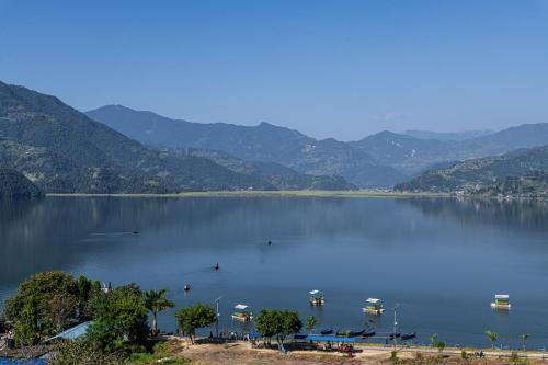 a large body of water with mountains in the background at Hotel Fewa Camp in Pokhara