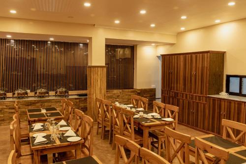 a dining room with wooden tables and chairs at Hotel Fewa Camp in Pokhara