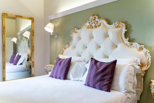 a bedroom with a large white bed with purple pillows at Art Hotel Villa Agape - Place of Charme in Florence