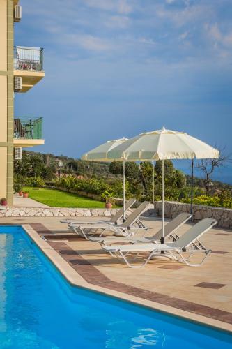 a group of lounge chairs and an umbrella next to a swimming pool at Eagle's Nest in Lourdhata