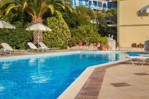 a large swimming pool with chairs and an umbrella at Eagle's Nest in Lourdhata