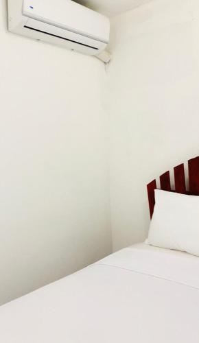 a bedroom with a white bed with a white pillow at Villa Marcia in Boca Chica