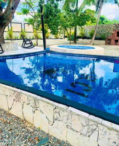 a swimming pool with blue water in a yard at Villa Marcia in Boca Chica