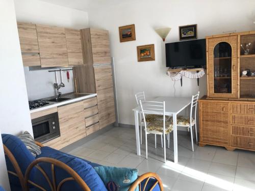 una cucina con tavolo e sedie in una stanza di Appartamento Iris 300 mt spiaggia a San Teodoro