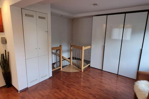a living room with white cabinets and a staircase at Wohnung mit Garten, Sauna und Infrarotkabine in Mühldorf