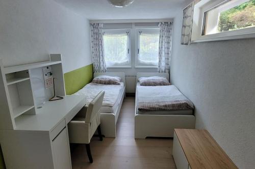 Kleines Zimmer mit 2 Betten und einem Schreibtisch. in der Unterkunft Wohnung mit Garten, Sauna und Infrarotkabine 