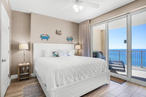 - une chambre avec un lit et un balcon donnant sur l'océan dans l'établissement Ocean Villa 1303, à Panama City Beach