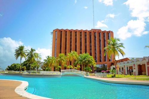 a large pool of water in front of a tall building at Tibisay Hotel Maturin in Maturín