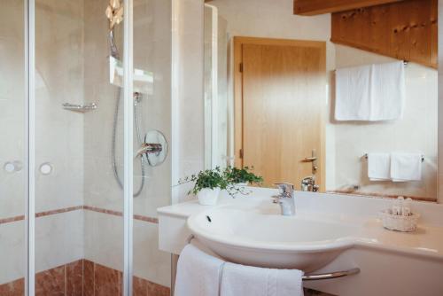 a bathroom with a sink and a shower at Oberaldoss Residence Wellness in Santa Cristina in Val Gardena