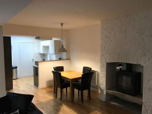 a dining room table with chairs and a fireplace at City Center House, Cardiff, parking permit and garden in Cardiff