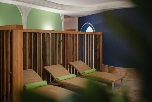 two chairs with green cushions sitting in a room at Oberaldoss Residence Wellness in Santa Cristina in Val Gardena