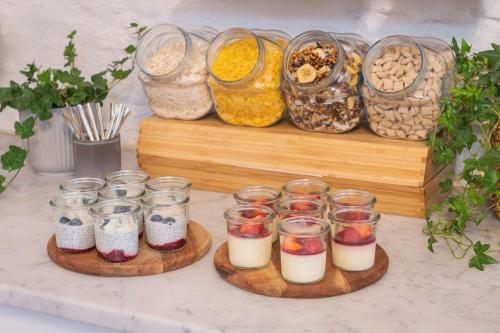 two wooden plates with different types of food in jars at Hotel Gamla Stan, BW Signature Collection in Stockholm