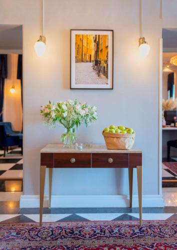 a table with a vase of flowers on it at Hotel Gamla Stan, BW Signature Collection in Stockholm