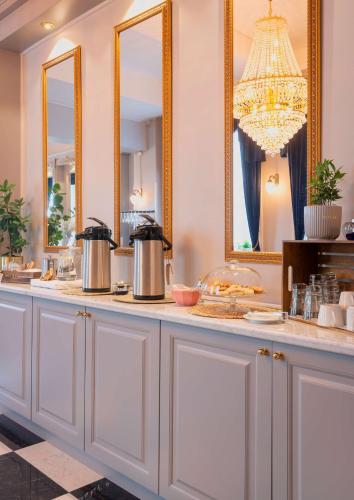 a buffet with two mirrors and a chandelier at Hotel Gamla Stan, BW Signature Collection in Stockholm
