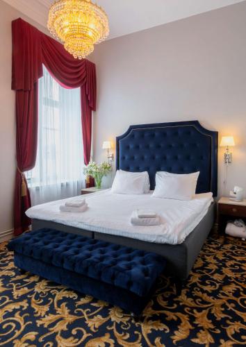 a bedroom with a blue bed with a chandelier at Hotel Gamla Stan, BW Signature Collection in Stockholm