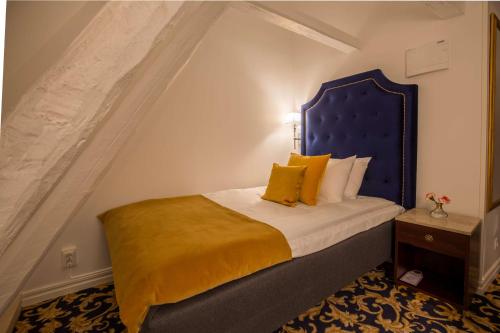 a bedroom with a large bed with a blue headboard at Hotel Gamla Stan, BW Signature Collection in Stockholm