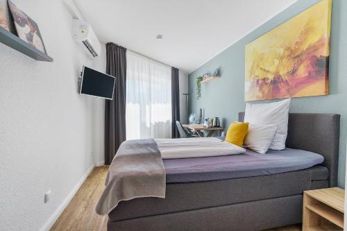 1 dormitorio con 1 cama con una pintura en la pared en Hotel garni Marktterrassen, en Hennef