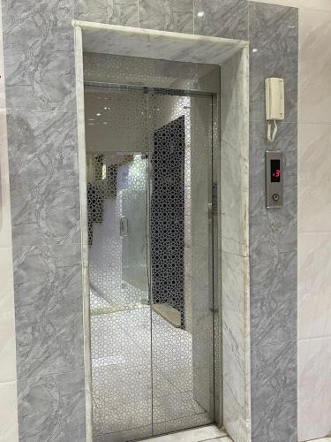 una porta a vetri in un bagno con specchio di ركن الهدوء a Muhayil
